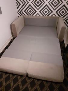 a white couch sitting in the corner of a room at Appart cosy Disney paris in Chalifert