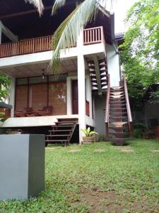 a house with a staircase on the side of it at Liyana Holiday resort in Anuradhapura