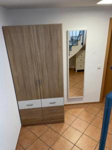 ein großer Holzschrank in einem Zimmer mit Spiegel in der Unterkunft Gästehaus Maxi in Rust