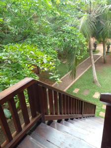 um banco de madeira sentado no topo de um deque de madeira em Liyana Holiday resort em Anuradhapura