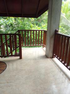 une terrasse couverte d'une maison avec balustrade en bois dans l'établissement Liyana Holiday resort, à Anurâdhapura