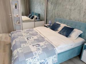 a bedroom with a blue bed and a mirror at Simona Apartament Iulius Mall in Iaşi