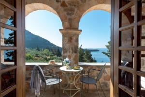 a room with a table and chairs on a balcony at Kalamitsi Hotel in Kardamyli