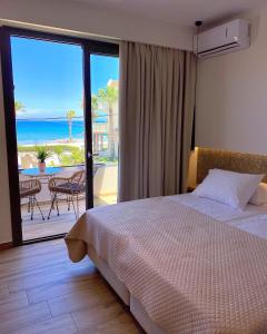 a bedroom with a bed and a view of the ocean at Roula Kotsonis Superior Apartment in Argassi