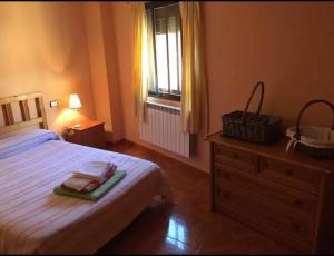 a bedroom with a bed and a dresser and a window at Casa en el corazón de Gredos, amplia y agradable. in Navacepeda de Tormes