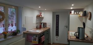 eine kleine Küche mit einem Schreibtisch und einem Fenster in der Unterkunft Ferienwohnung MAI in Glauchau