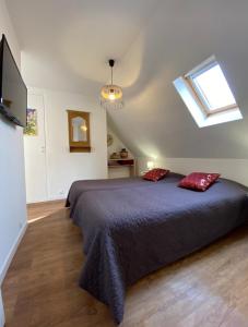 L'Ours de Colmar - Appartements en centre ville في كولمار: غرفة نوم بها سرير ووسادتين حمرا