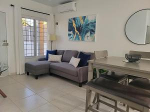 uma sala de estar com um sofá e uma mesa em Linda, cerca de todo, parqueo, patio, netflix em La Ceiba
