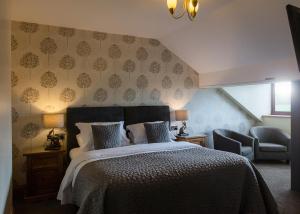 a hotel room with a bed and two lamps at Laundimer House Bed & Breakfast in Corby