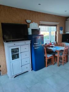 NadoleにあるGrabówkaのキッチン(青い冷蔵庫、ダイニングルーム付きのテーブル付)
