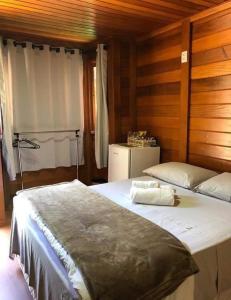 a bedroom with two beds and a refrigerator at Pousada Recanto Viva a Vida in Domingos Martins
