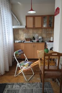 una cocina con una silla y una mesa. en E-19 Home - Tradition meets tourism, en Prizren
