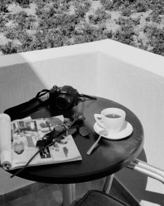 a table with a camera and a cup of coffee at Lefteris Houses in Karterados