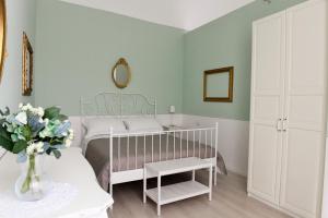 een slaapkamer met een wit bed en een vaas met bloemen bij Dimora del Castellano GREEN HOUSE in Gioia del Colle +27 foto's