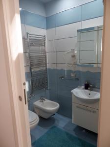een badkamer met een wastafel, een toilet en een spiegel bij Lo scrigno del mare in Polignano a Mare