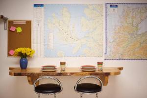 a table with two chairs and a map on the wall at Hidden Gem in a great location very near Isle of Skye in Kyle of Lochalsh