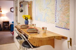 una mesa de madera con cuencos con un mapa en la pared en Hidden Gem in a great location very near Isle of Skye, en Kyle of Lochalsh