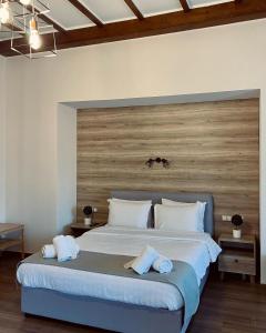 una camera con un grande letto con testiera in legno di 11 Luxury Apartments a Metsovo