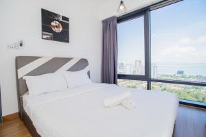 ein weißes Bett in einem Zimmer mit einem großen Fenster in der Unterkunft Tropicana 218 MACALISTER in George Town + 100 Fotos