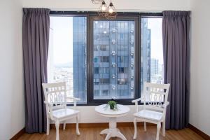 Zimmer mit 2 Stühlen und einem Tisch vor einem Fenster in der Unterkunft Tropicana 218 MACALISTER in George Town