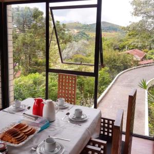 a dining table with a view of a mountain view at Pitaya Suítes in Cunha