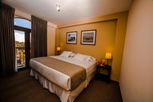 ein Hotelzimmer mit einem Bett und einem Fenster in der Unterkunft ATOJJA CHUCUITO HOTEL in Puno