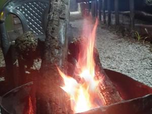 a fire in a fire pit next to a bench at Bluepine Cottages Pangot by Nature Nests in Nainital