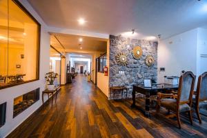 a living room with a table and a stone wall at Katari Atojja Puno Hotel in Puno