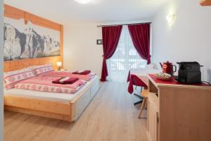 sypialnia z łóżkiem i biurkiem w obiekcie B&B Agriturismo Cèsa Ciasates w mieście Canazei