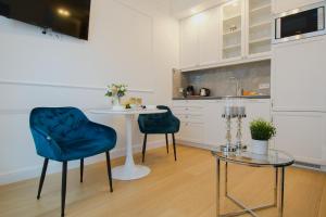 cocina con mesa y 2 sillas azules en Warsaw Seasons by Alluxe Boutique Apartments, en Varsovia