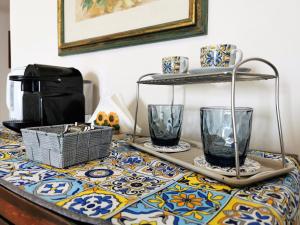 a table with two glass vases on top of it at Nesea Naxos - Sicilian Suite in Giardini Naxos