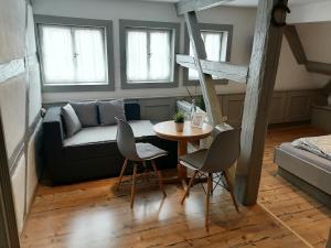 uma sala de estar com um sofá, uma mesa e cadeiras em Landhotel Alte Schmiede em Prichsenstadt mais 11 fotografias