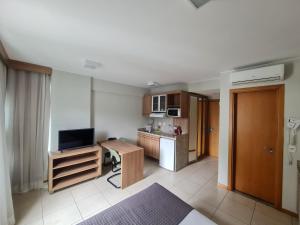 a small kitchen with a table and a television in a room at BSB FLAT - MELHOR LOCALIZAÇÃO in Brasilia