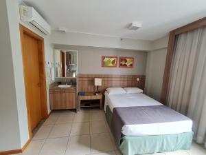 a hotel room with two beds and a bathroom at BSB FLAT - MELHOR LOCALIZAÇÃO in Brasilia