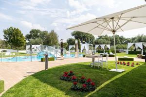 einen Park mit Sonnenschirm und Spielplatz in der Unterkunft Hotel Villa Sofia in Viterbo