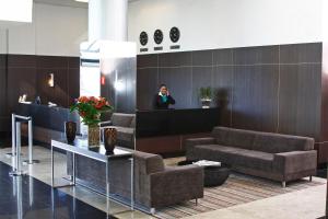 a woman talking on a cell phone in a lobby at Piemonte Hotel in Nova Lima