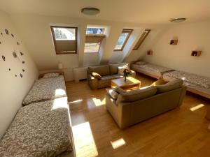 a attic room with two beds and a couch at JZ Apartments - Pohorje in Maribor