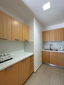una cocina con armarios de madera y fregadero en JZ Apartments - Pohorje, en Maribor