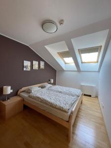 a bedroom with a bed and two skylights at JZ Apartments - Pohorje in Maribor