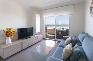 a living room with a blue couch and a television at AG Aquarium in Playa de Gandia