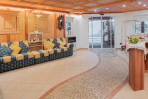 una gran sala de estar con sofás y una alfombra en Appartamenti Agriturismo Cèsa Ciasates, en Canazei