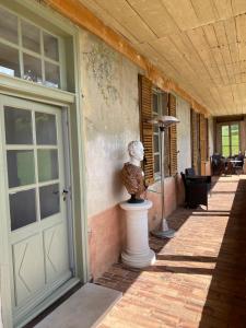 une statue assise sur un piédestal à côté d'une porte dans l'établissement Clos de Mont July, chambres avec vue et terrasse dans demeure historique, à Ceyzériat