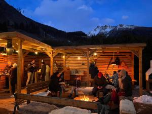 eine Gruppe von Menschen, die in einer Hütte am Feuer sitzen in der Unterkunft Mallnbach Apartments in Mallnitz