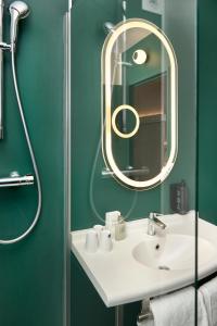 a bathroom with a white sink and a mirror at Ibis Annecy - Cran-Gevrier in Annecy