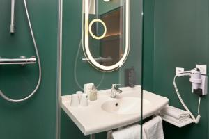 Baño verde con lavabo y espejo en Ibis Annecy - Cran-Gevrier en Annecy