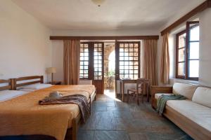 a hotel room with two beds and a couch at Kalamitsi Hotel in Kardamyli