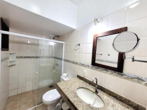 a bathroom with a sink and a mirror and a toilet at Pousada Centro Class in Búzios +30 photos