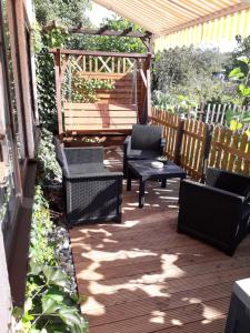 eine Terrasse mit Stühlen, einem Tisch und einer Bank in der Unterkunft Ferienwohnung Weingart Quedlinburg in Quedlinburg