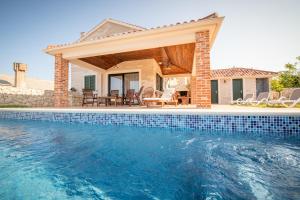 a house with a swimming pool in front of a house at Villa Molat in Molat