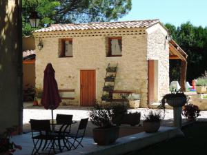 une maison avec une table, des chaises et une terrasse dans l'établissement Mas de la Sauline, à La Roque-dʼAnthéron